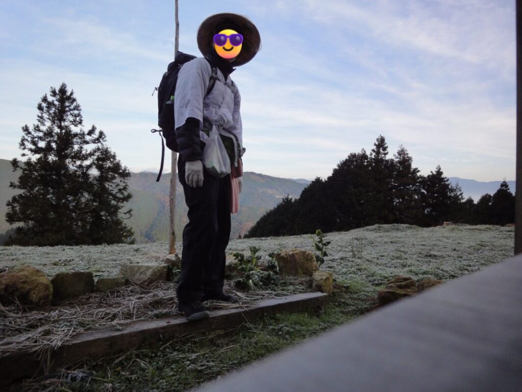 Me as a walking pilgrim: in white robes with a backpack — winter in the mountainous area of Ehime — the ground is covered with frost