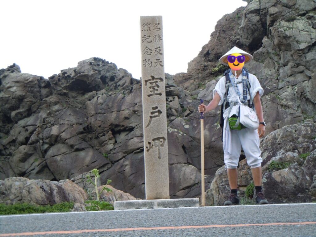 Walking pilgrim beside the Cape Muroto stone monument
